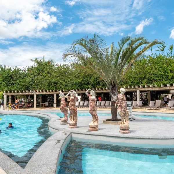 Piscina termal com estátuas e palmeira no L'acqua diRoma