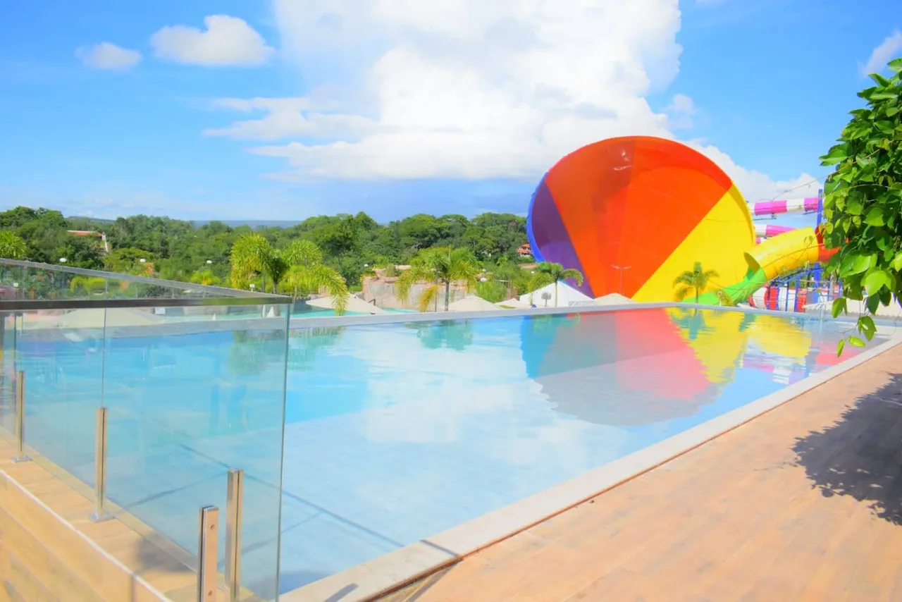 Piscina de borda infinita com toboágua arco-íris ao fundo no Kawana Park