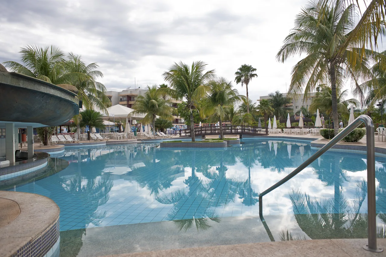 Piscina termal cercada de palmeiras no Náutico Praia Clube