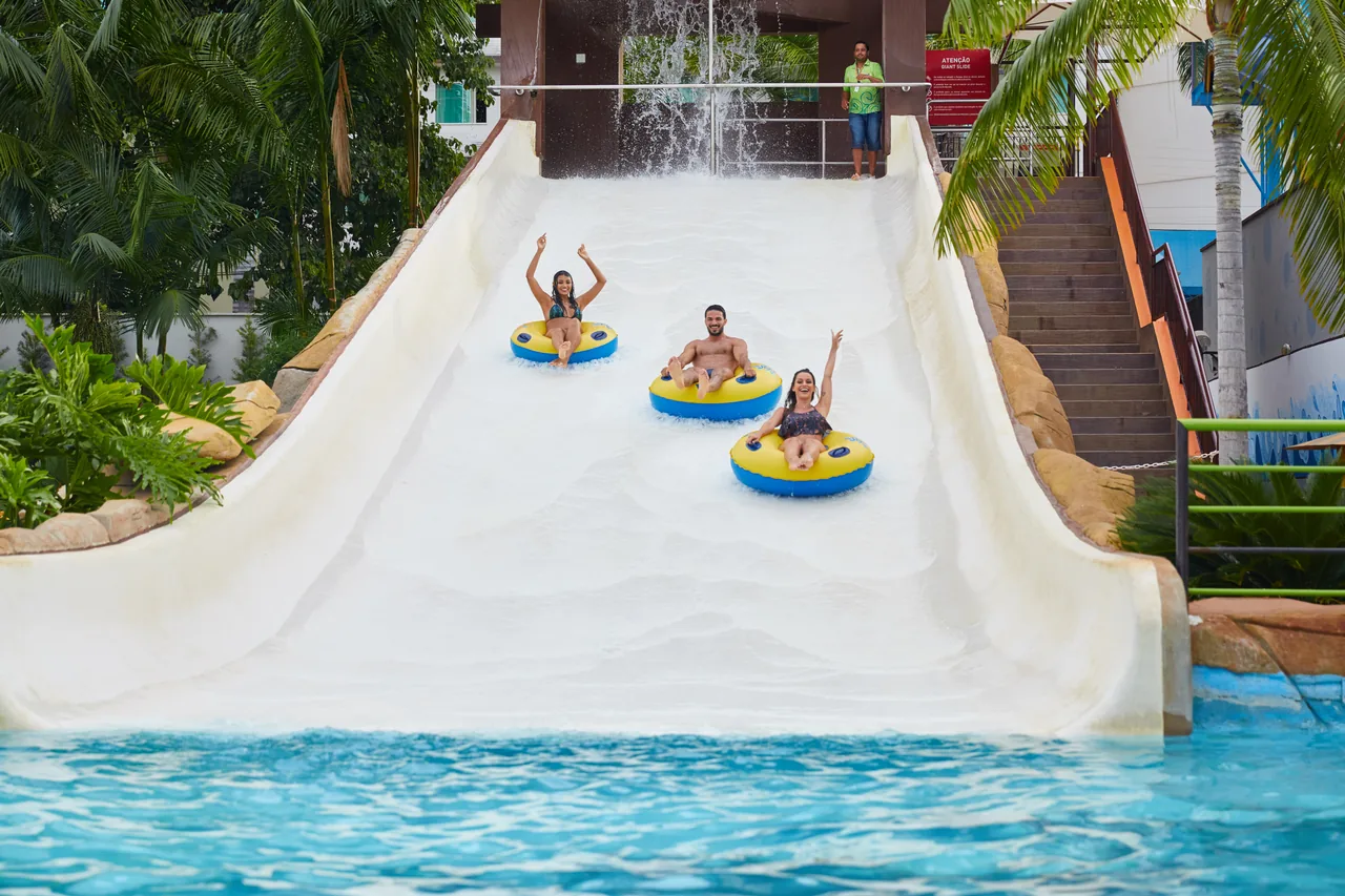 Visitantes descendo o toboágua Giant Slide em boias no Water Park